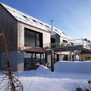 Pohled na zasněžený apartmánový dům na Lipně